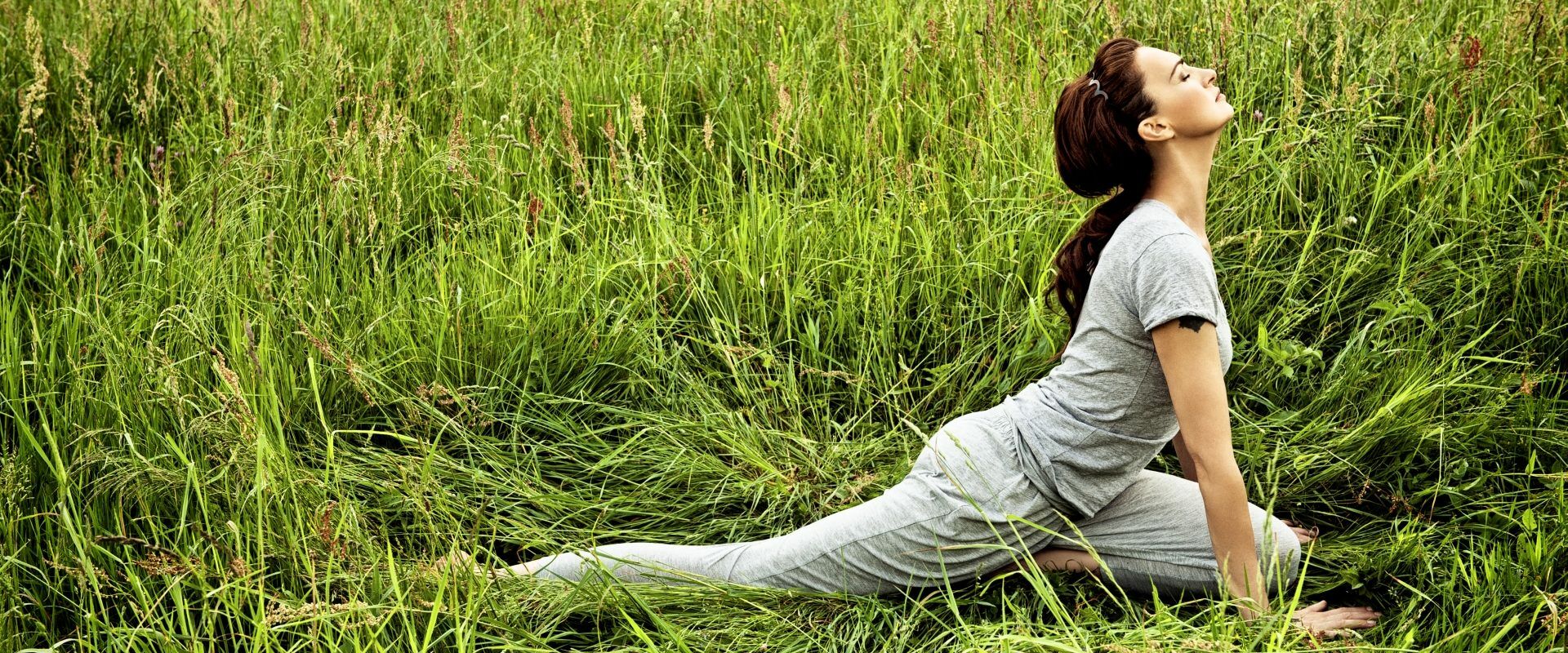 Agnieszka Maciąg ćwiczy jogę i medytuje na trawie.